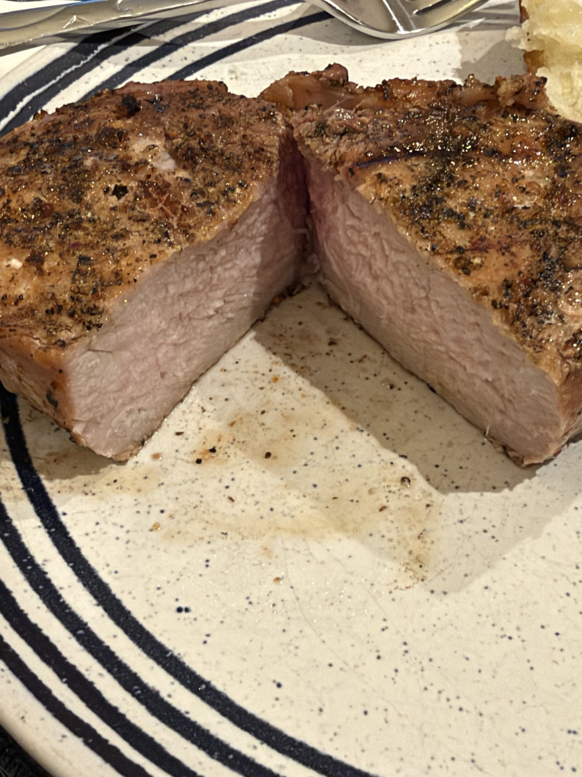 Bourbon-brined grilled pork chop sliced open to show the juicy interior