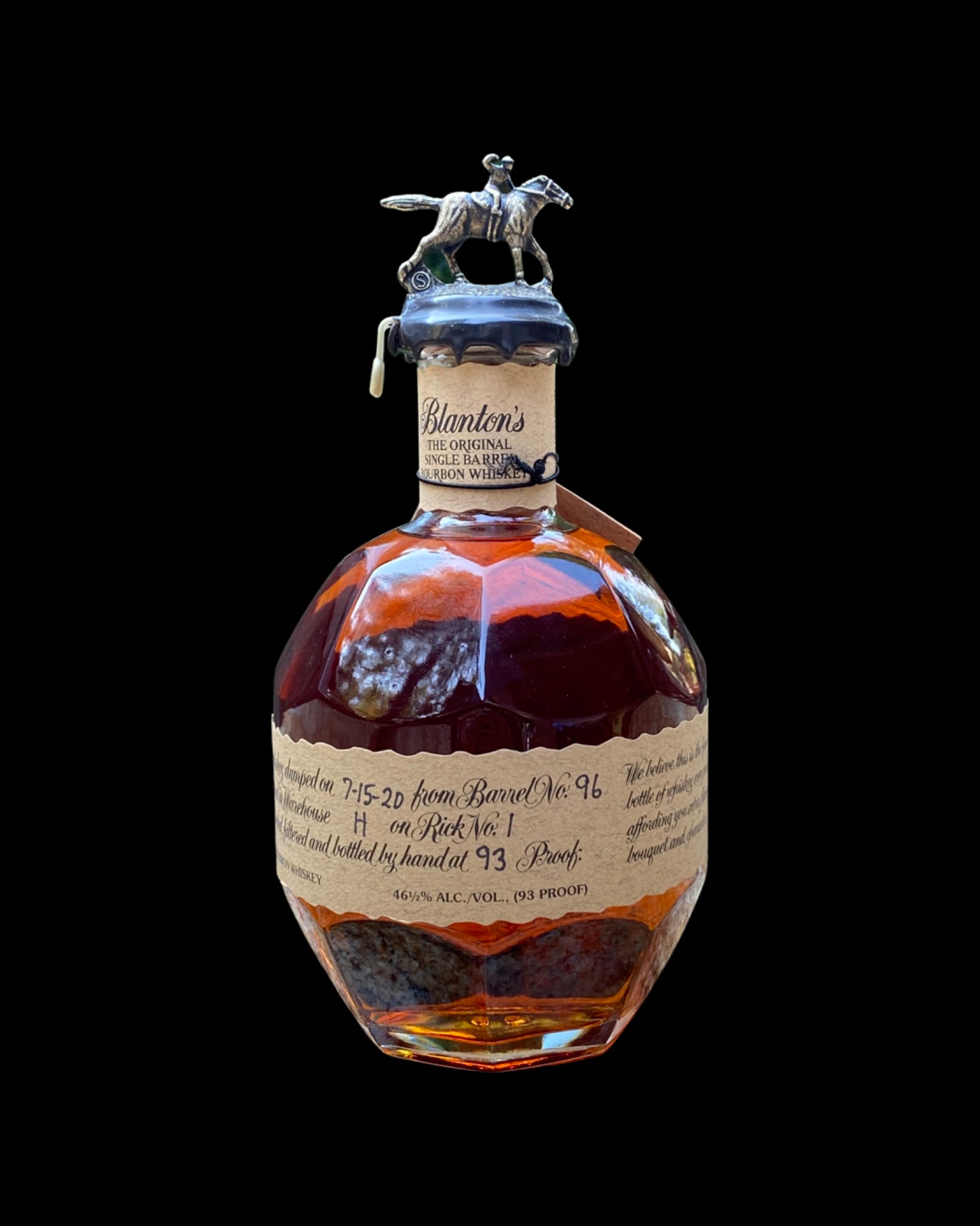 A premium bourbon bottle with a gold ribbon on a holiday table